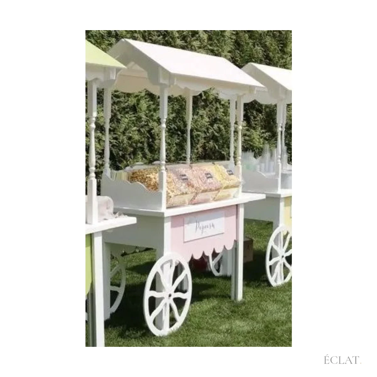 Charrette candy bar blanche à toit blanc garnie de pop-corn, grandes roues à rayons