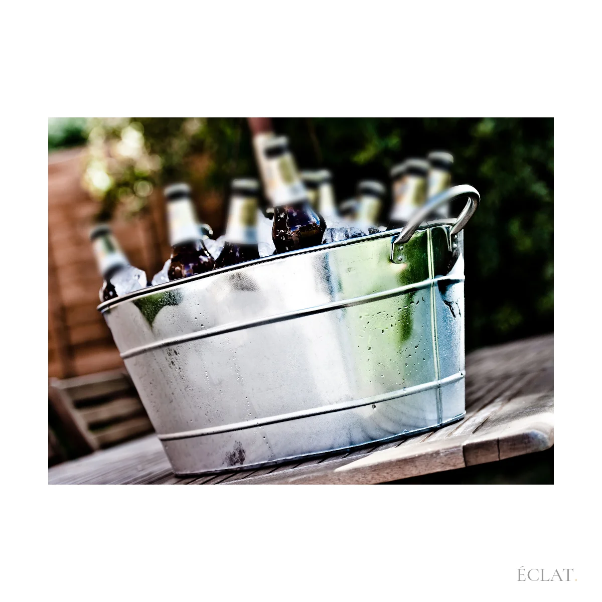 Seau à bière galvanisé rempli de glace et de bouteilles en terrasse