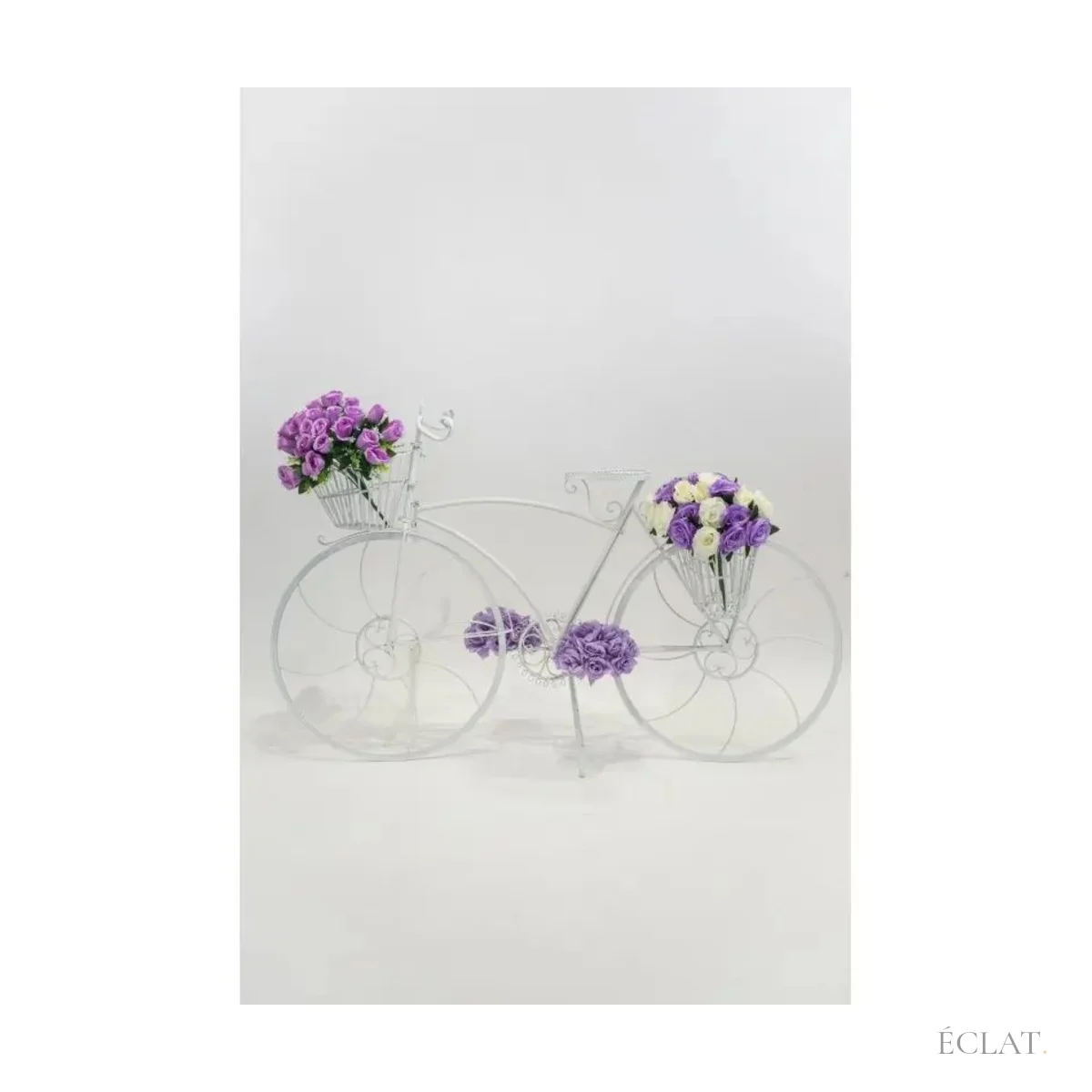 Vélo de décoration blanc aux roues en arabesques, vu de profil
