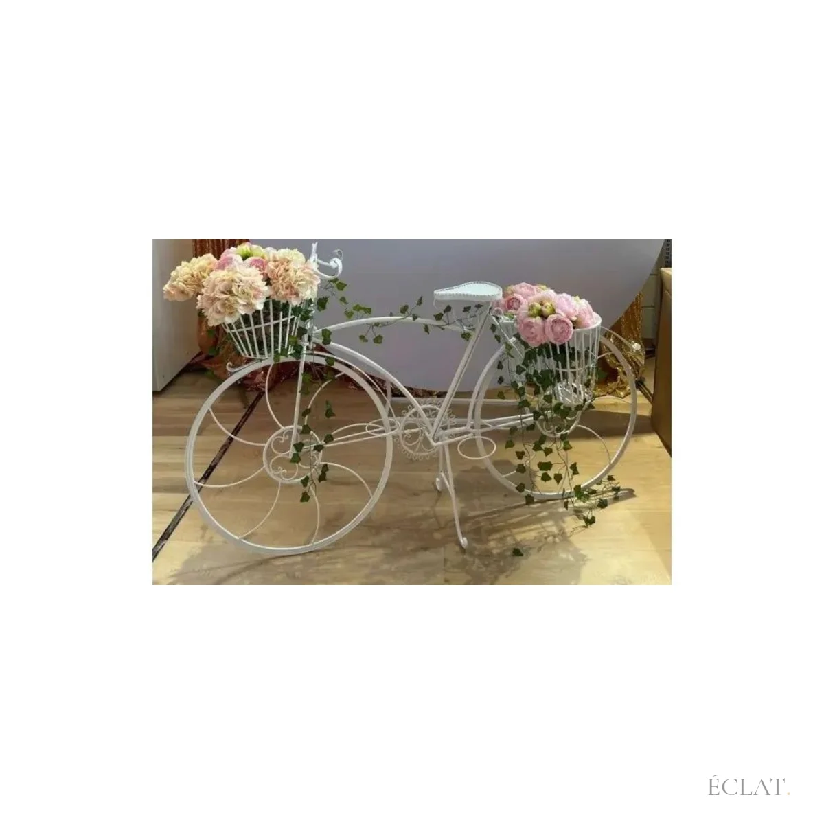 Vélo décoratif fleuri de pivoines et de lierre devant un fond de réception