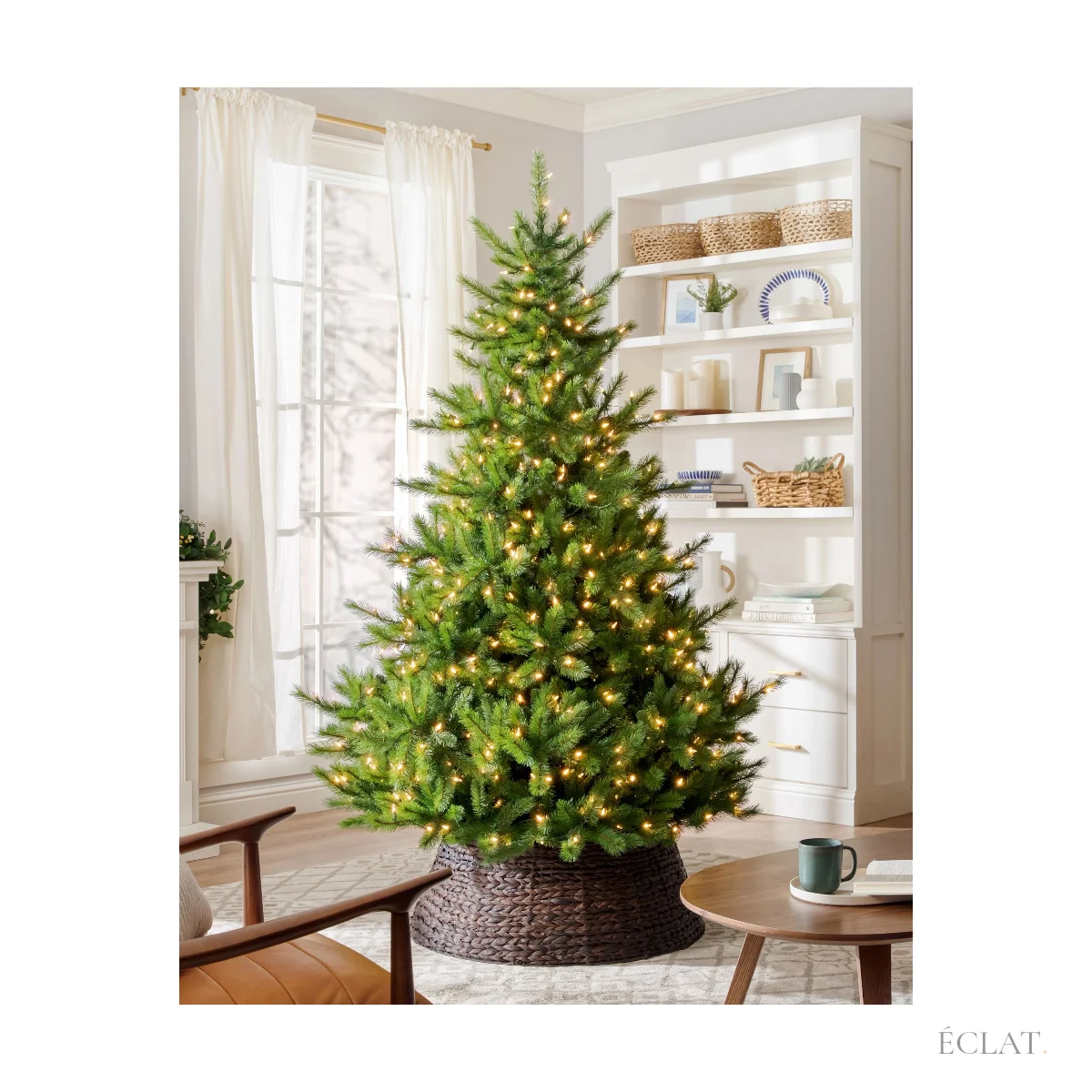 Sapin de Noël artificiel illuminé dans un salon, près d'une bibliothèque