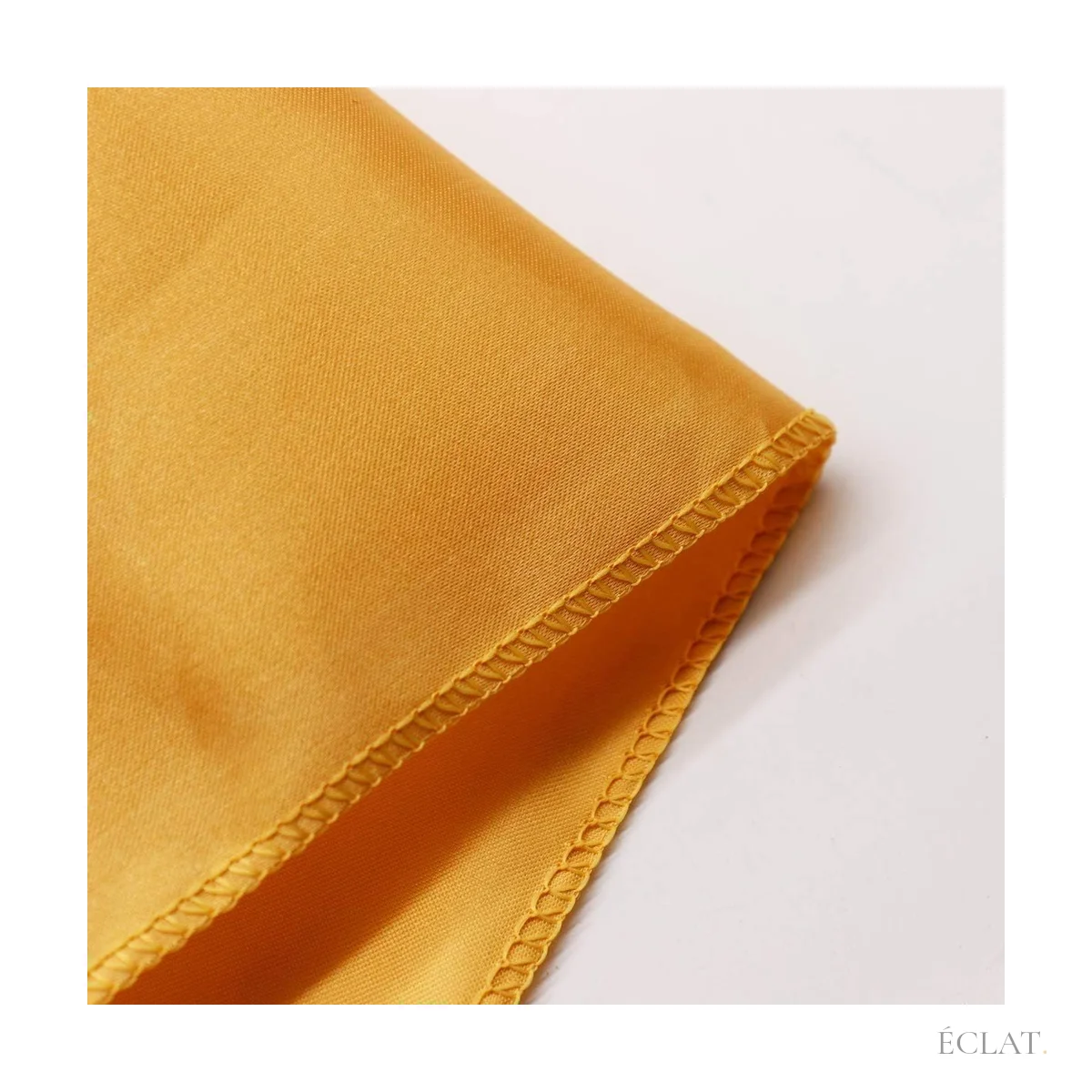 Ourlet surpiqué et reflets du satin doré de la nappe rectangulaire 228 × 335 cm